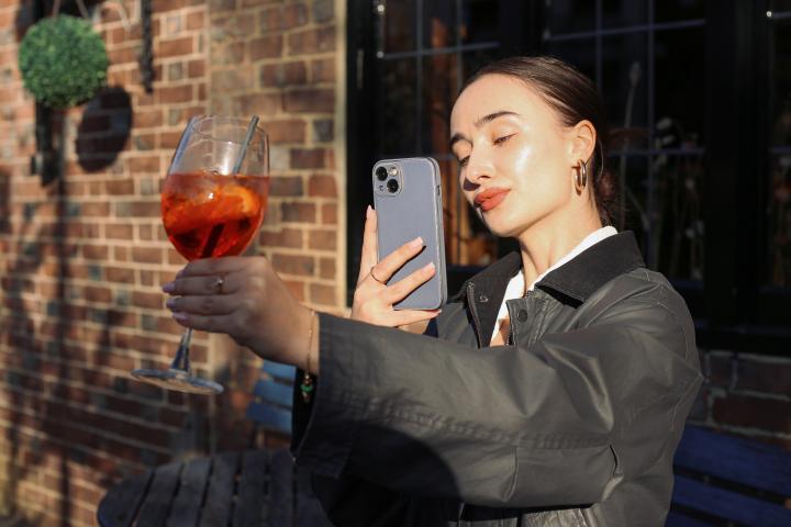 Imagen de archivo de una mujer tomándole una foto a una copa.