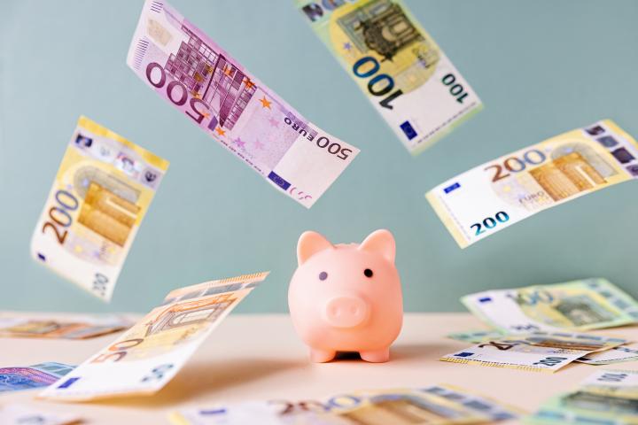 Una hucha junto a varios billetes de euro