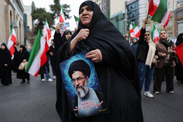 Una mujer sostiene una imagen del líder supremo de Irán, el ayatolá Ali Jamenei, el 28 de febrero de 2026, en las calles de Teherán, la capital.