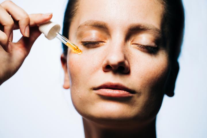 Una mujer aplicándose un sérum