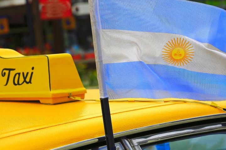 Imagen de un taxi en Buenos Aires con la bandera de Argentina.