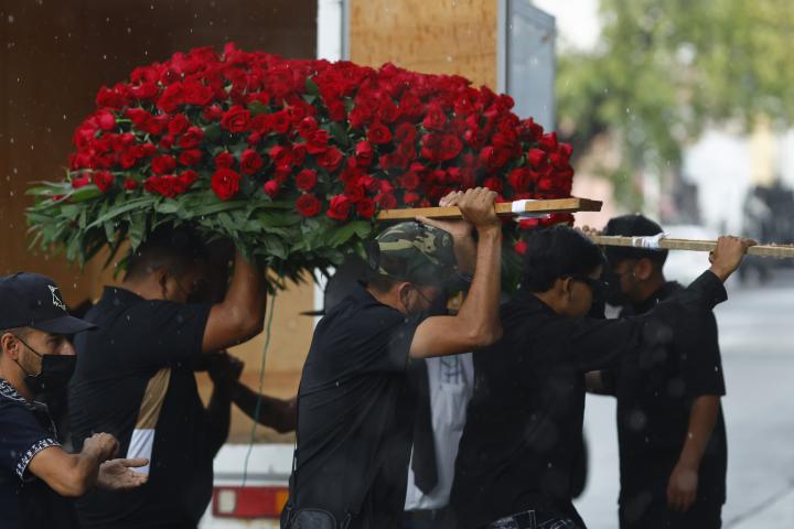 Personas cargan un arreglo floral durante la velación de Nemesio Oceguera Cervantes, alias El Mencho