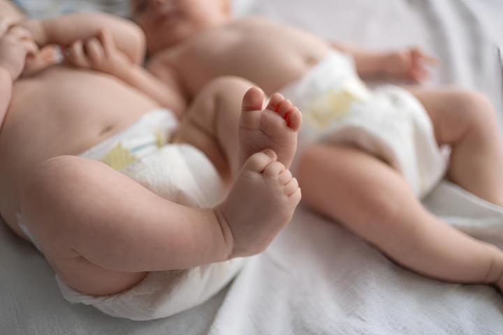 Las piernas de dos bebés gemelos