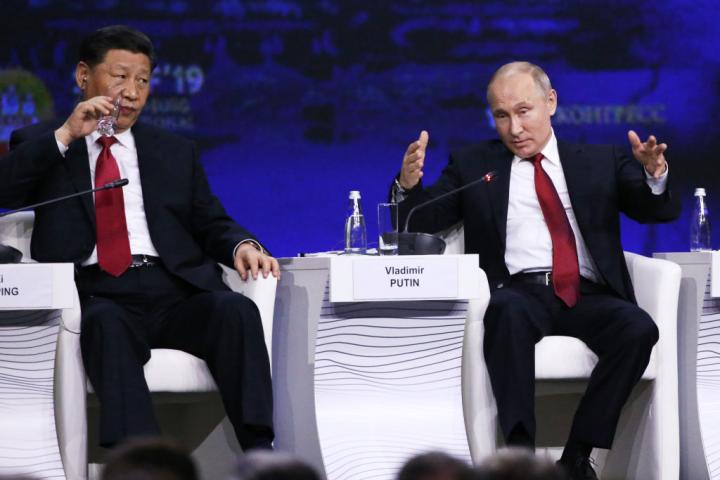 El presidente chino, Xi Jinping, bebe agua mientras observa a un gesticulante presidente ruso, Vladimir Putin, en el Foro Económico Internacional de San Petersburgo, el 6 de junio de 2019.