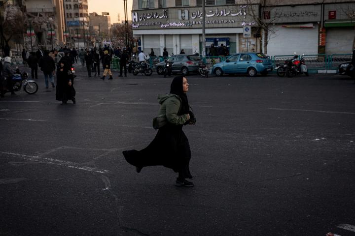 Una mujer corre por una calle tras un ataque israelí y estadounidense a una comisaría de policía en Teherán (Irán), el 3 de marzo de 2026.