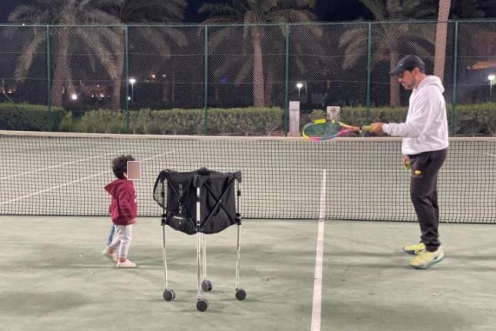 Faus, junto a su hijo, en una de las pistas de tenis en las que da clases