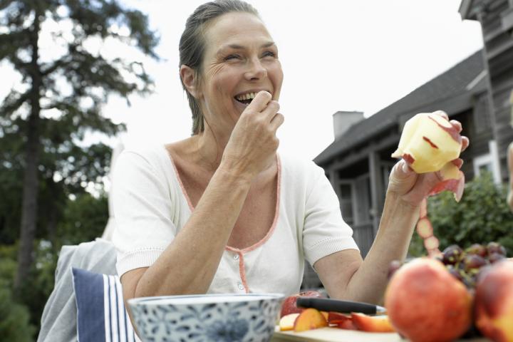 Imagen de archivo de una mujer comiendo fruta.