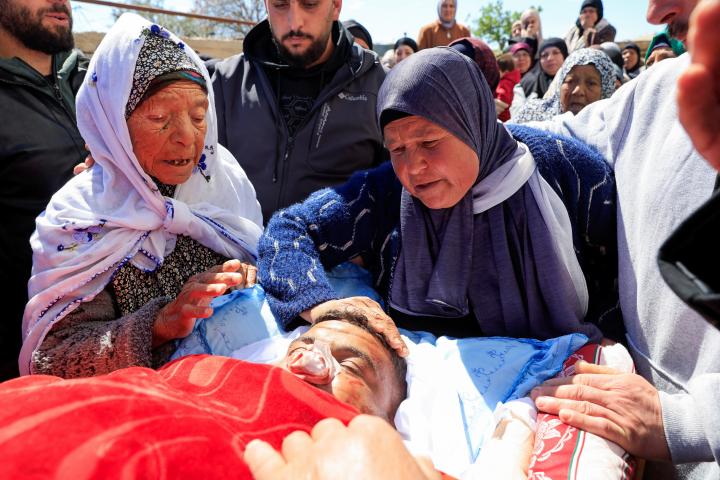 Unas mujeres lloran junto al cuerpo de Ameer Shanaran, palestino asesinado en un ataque colono, durante su funeral en Yatta, cerca de Hebrón (Cisjordania), el 8 de marzo de 2026.