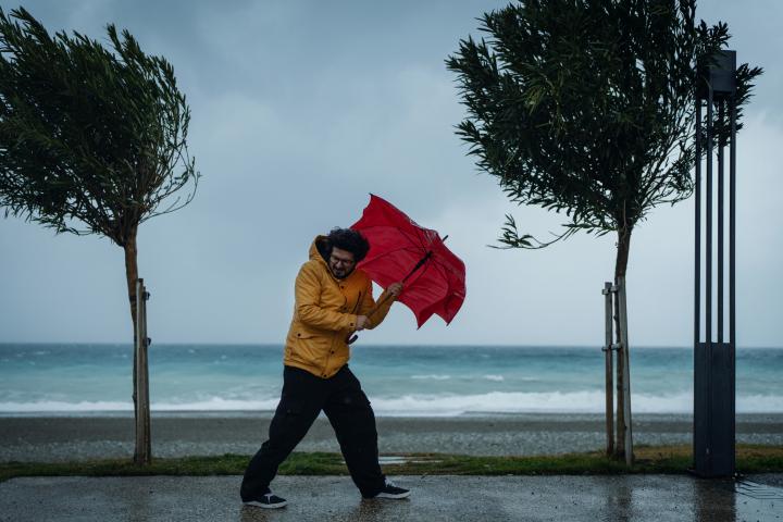 Un hombre usa un paraguas bajo la tormenta
