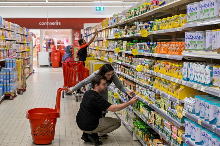 Unos clientes consultan los precios de unos alimentos en el supermercado de la cadena Continente Telheiras, el 18 de abril de 2023, en Lisboa (Portugal).