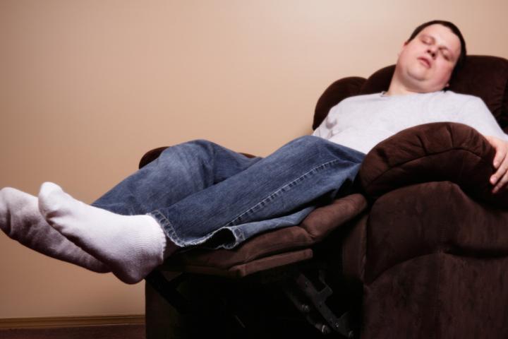 Un hombre durmiendo con calcetines en un sillón