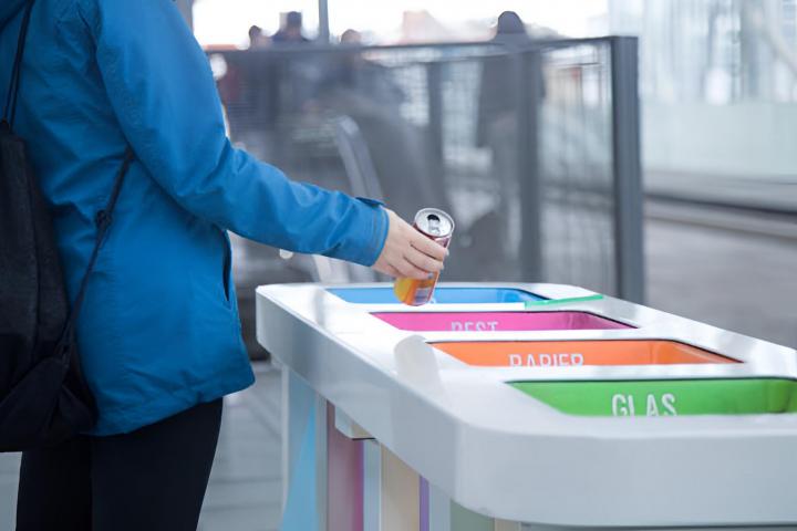 Un joven tirando una lata a su contenedor correspondiente