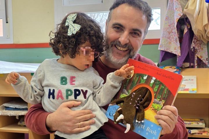 Israel Coronado, con la pequeña Loreto, durante una lectura en un centro educativo.