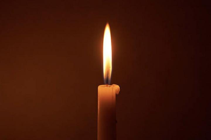 Una vela encendida y alumbrando una habiitación