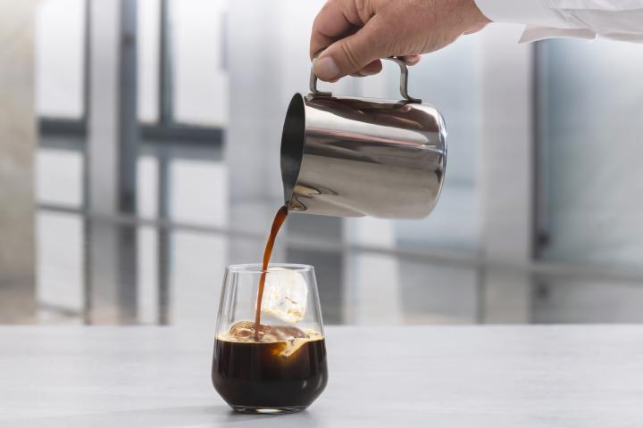 Un camarero, sirviendo un café con hielo.