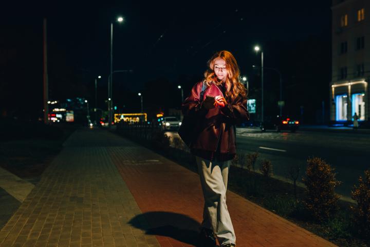 Imagen de archivo de una mujer caminando por la noche.