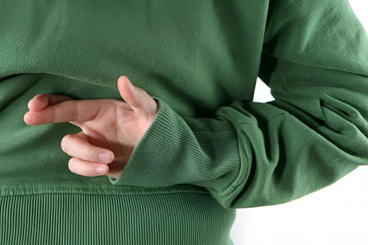 Una persona cruzando los dedos detrás de su espalda