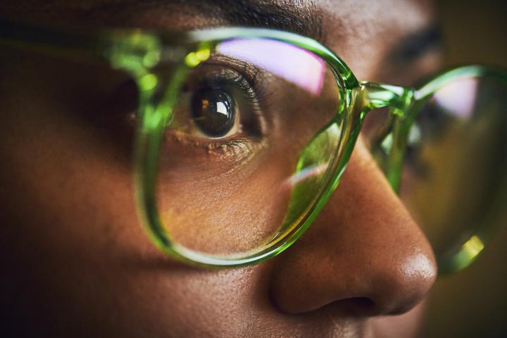 Persona utilizando gafas, mirando fijamente.