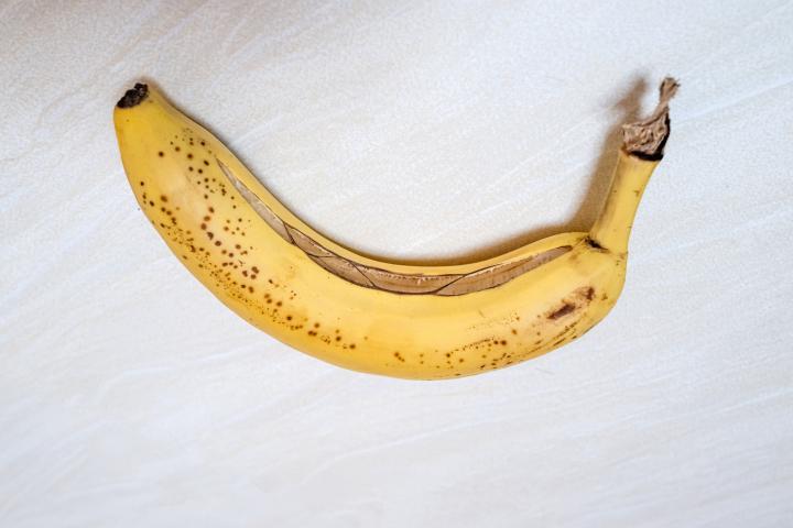 Un plátano con la cáscara rota parcialmente.