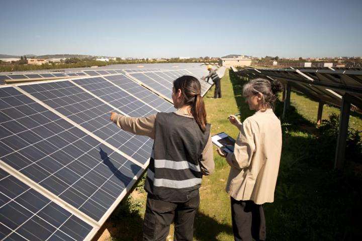Ingeniera mostrando paneles solares a un empresario veterano durante una visita a la central eléctrica