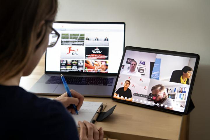 Una mujer toma notas durante una videollamada de trabajo