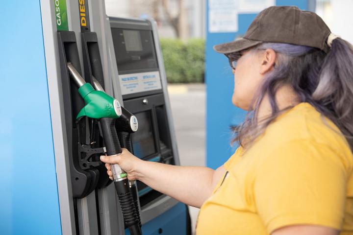 Una mujer reposta en una gasolinera