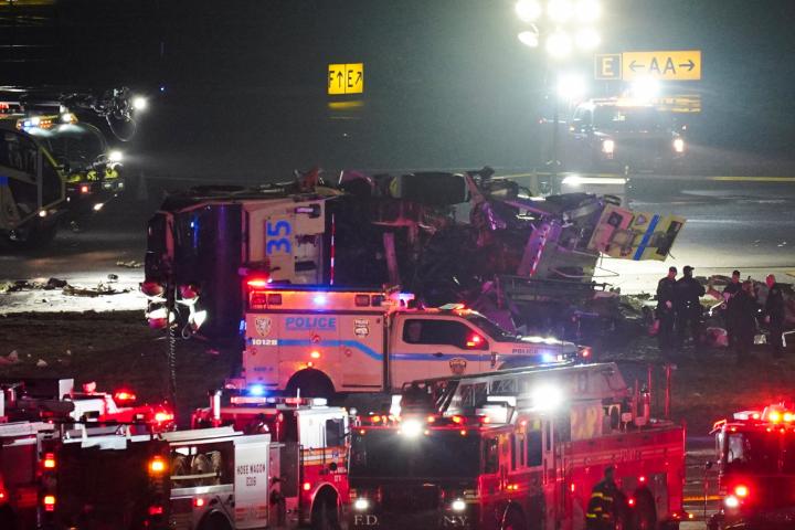 Los servicios de emergencia asisten al vehículo que ha chocado en la pista del aeropuerto de LaGuardia con un avión de Air Canadá, el 23 de marzo de 2026, en Nueva York.