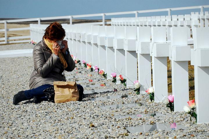 Una mujer llora ante las tumbas de soldados argentinos muertos en la guerra de las Malvinas, en el Monumento a los Caídos de San Carlos, el 3 de octubre de 2009 en Darwin.