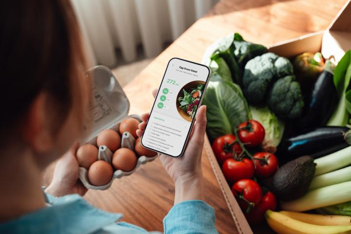 Una mujer mira a través del móvil los alimentos que tiene delante