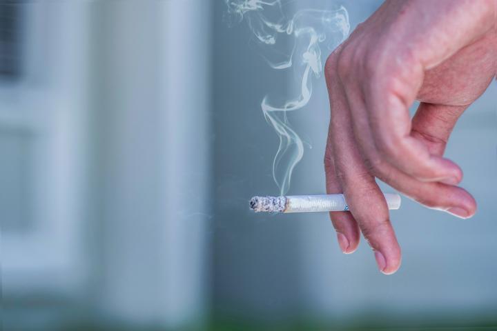 Un fumador sosteniendo un cigarrillo