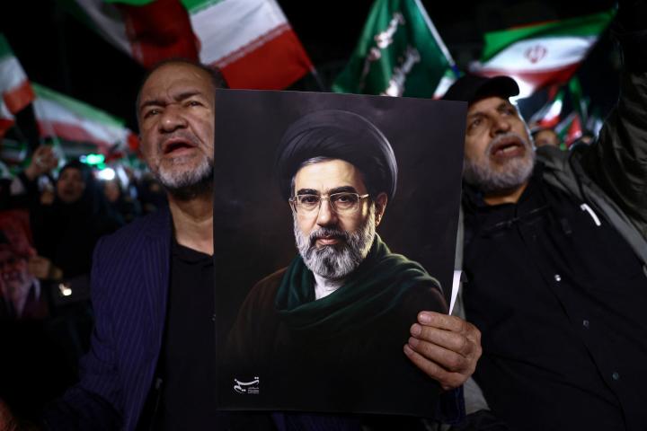 Un hombre sostiene un cartel con el nuevo líder supremo de Irán, Mojtaba Jamenei, en una manifestación antiestadounidense e israelí en Teherán, el 22 de marzo de 2026.