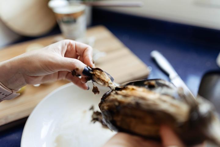 Una persona pela una berenjena