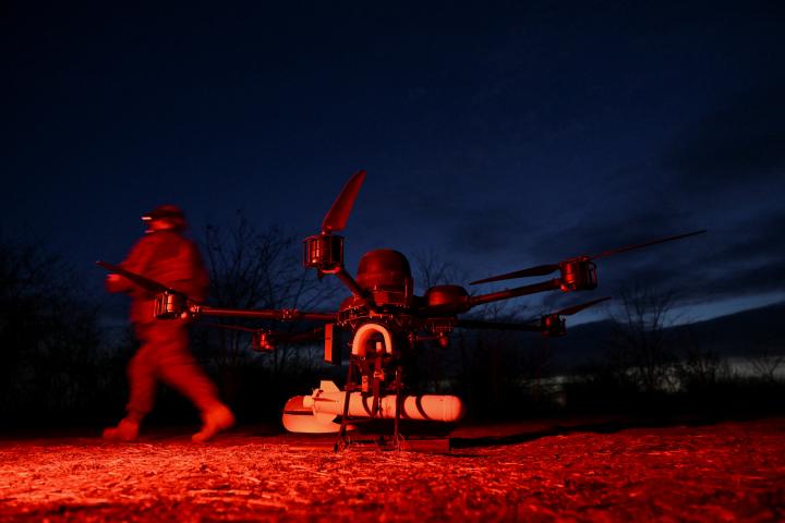 Un miembro del 422.º Regimiento de Sistemas No Tripulados camina junto a un dron en un campo de entrenamiento, en la región de Zaporiyia (Ucrania), el 23 de marzo de 2026. REUTERS/Stringer