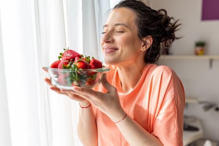 Una mujer comiendo fresas
