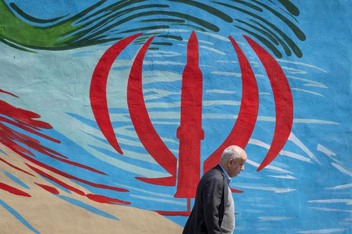 Un hombre pasa junto a un mural con los colores nacionales y un misil en Teherán (Irán), el 30 de marzo de 2026, en el contexto del ataque de EEUU e Israel.