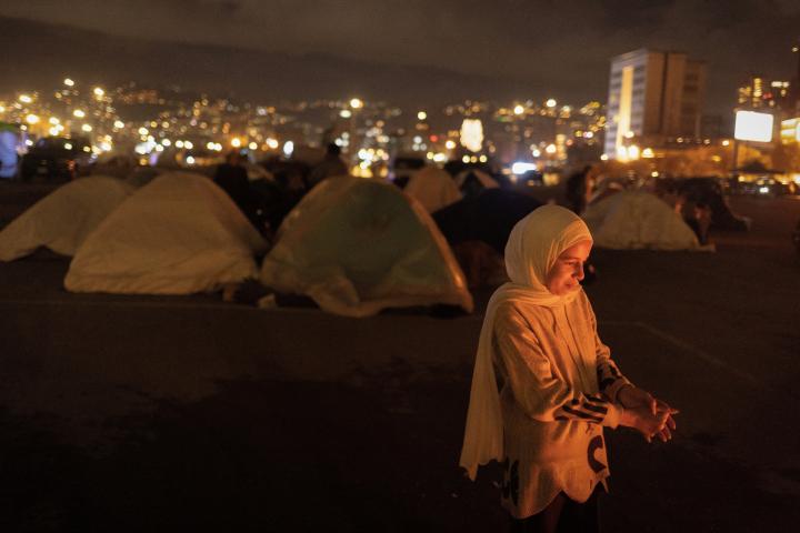 Nariman, una huérfana de 12 años, junto a una hoguera en un campo de tiendas de desplazados, el 30 de marzo de 2026, en Beirut (Líbano).