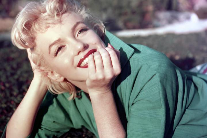 alt="alt="La actriz Marilyn Monroe posa para un retrato tumbada sobre la hierba en 1954 en Palm Springs, California.""