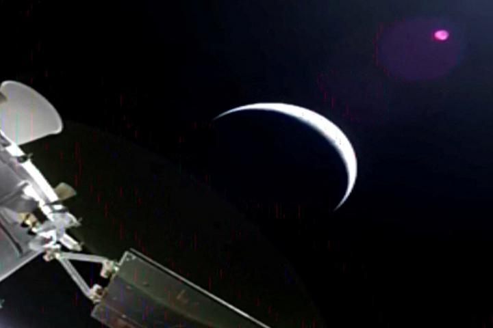 La cápsula Orión de la misión Artemis II abandona la Tierra, iluminada por el sol en forma de media luna, rumbo a su paso por el satélite, el 2 de abril de 2026.