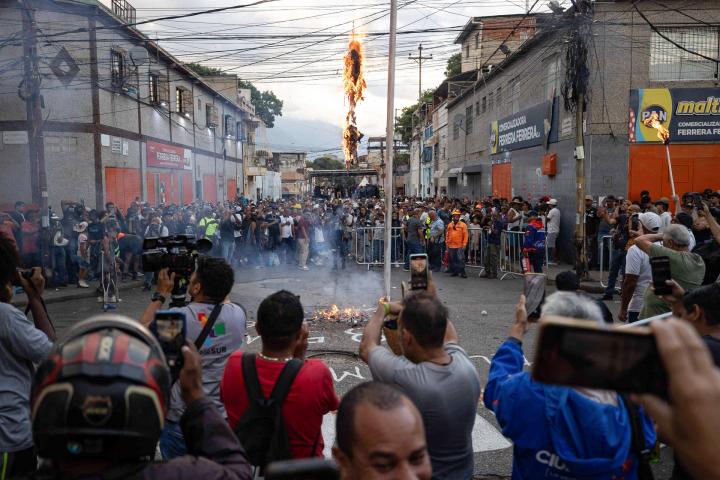Personas observan la tradicional Quema de Judas este domingo, durante la celebración de Semana Santa en Caracas (Venezuela).