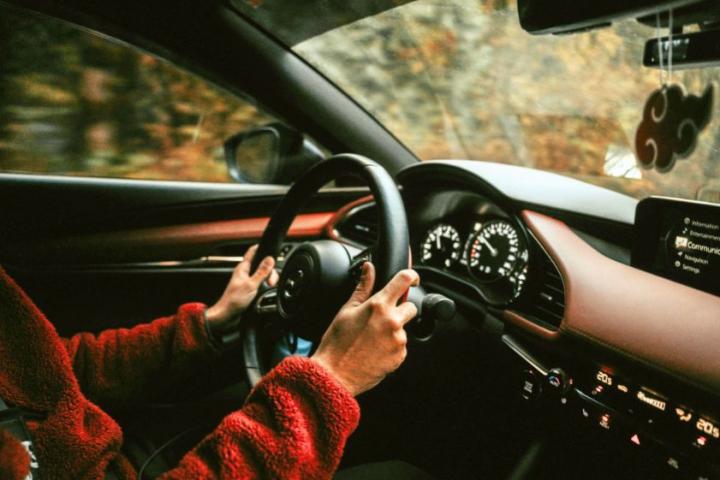 Un hombre conduce su automóvil.