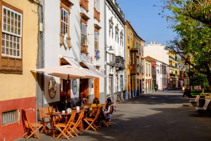 People sitting at the outdoor tables in one of the historic alleys of San Cristóbal de La Laguna (commonly known as La Laguna), a city in the northern part of Tenerife whose old town has been declared a World Heritage Site by UNESCO.