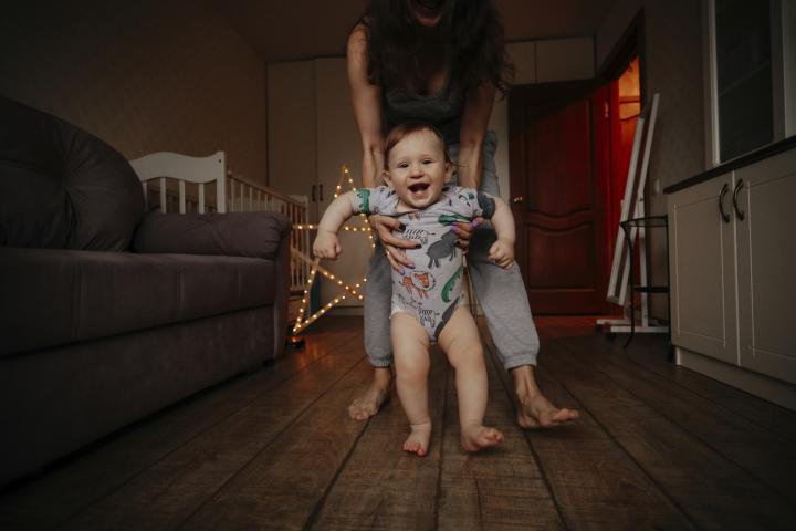 Un bebé y su madre andan descalzos por casa