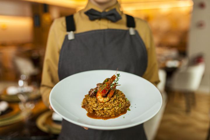 Una camarera, sirviendo un plato.