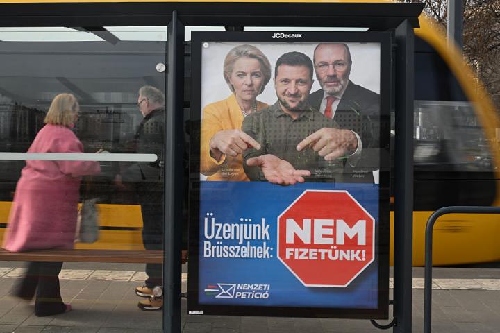Campaña estatal con la presidenta de la CE, Ursula von der Leyen; al presidente ucraniano, Volodimir Zelenski, y el del PPE, Manfred Weber, en una parada de tranvía en Budapest, el 4 de marzo de 2026.A government 'National Petition' campaign billboard depicting European Commission President Ursula von der Leyen, Ukrainian President Volodymyr Zelenskyy, and EPP leader Manfred Weber is displayed at a tram stop in Budapest on March 4, 2026. (Photo by Artur Widak/NurPhoto via Getty Images)