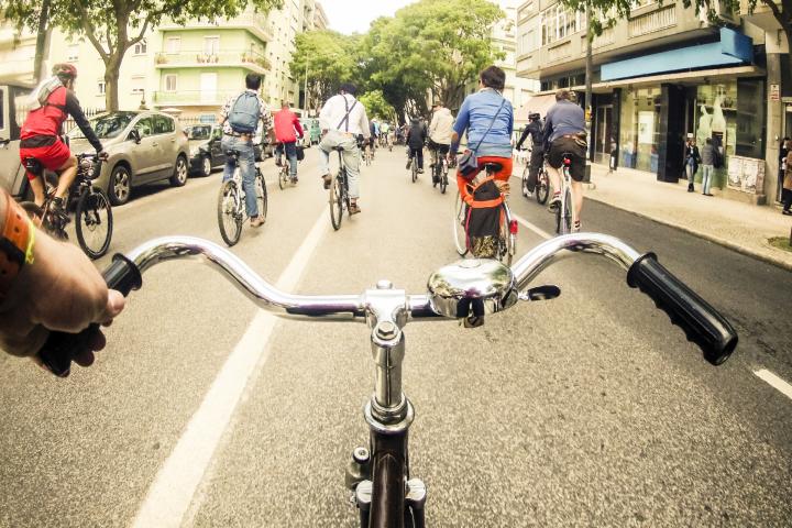 Varias personas, en bici por una calle.