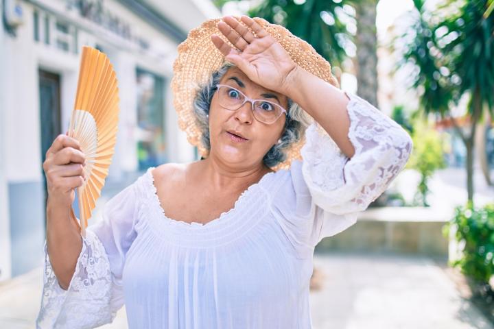 Una mujer abanicándose