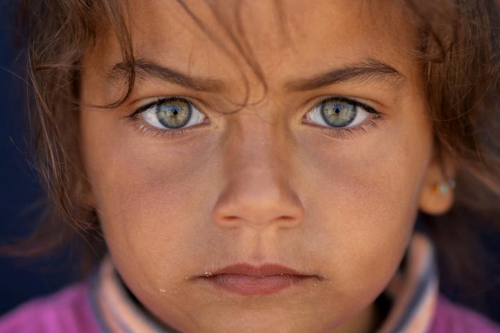 Silva Shouman, de cinco años, observa sentada detrás de un camión en un campamento improvisado en Beirut, Líbano, el 13 de abril de 2026, tras escapar de las bombas de Israel.