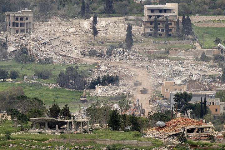 Blindados israelíes se mueven cerca de casas destruidas en el sur del Líbano, vistos desde una posición en el lado israelí de la frontera, el 15 de abril de 2026.