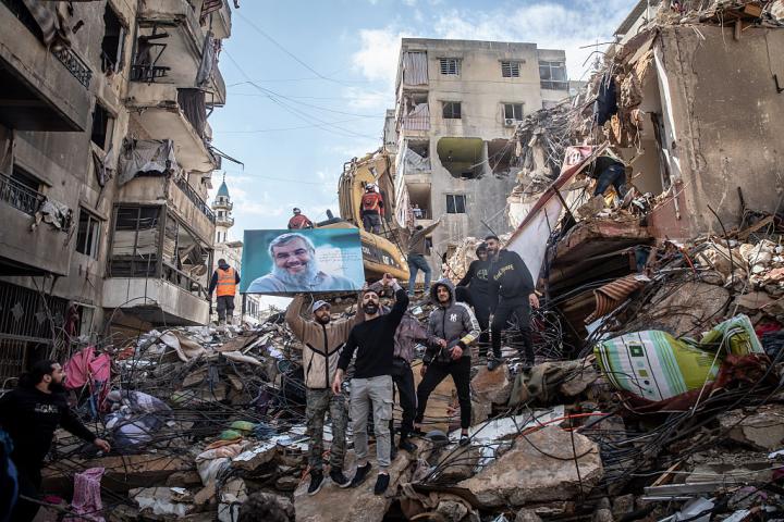 Partidarios de Hezbolá muestran una fotografía del asesinado líder Hassan Nasrallah en Hey al-Soulom, en los suburbios del sur de Beirut, el 12 de abril de 2026, entre ruinas de ataques de Israel.
