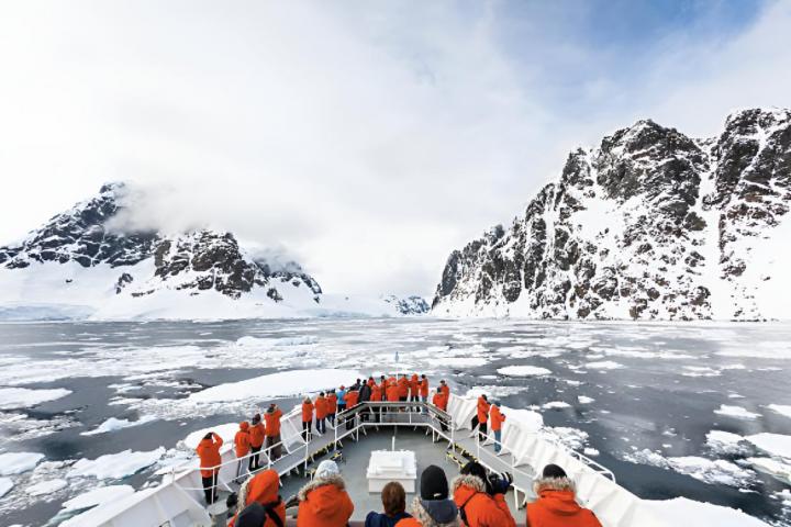 Un barco lleno de gente atravesando la congelada Antártida